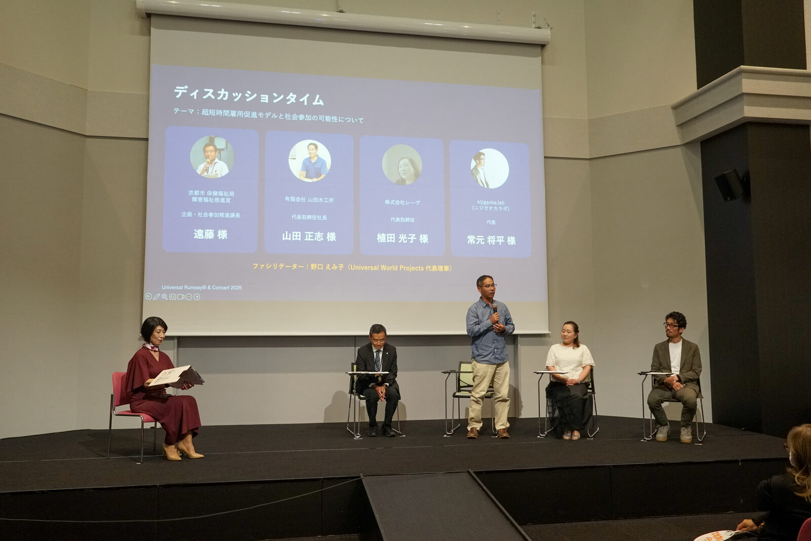 ディスカッション中の舞台全景。左端にファシリテーターの野口さん、右に4名の登壇者が座っている。