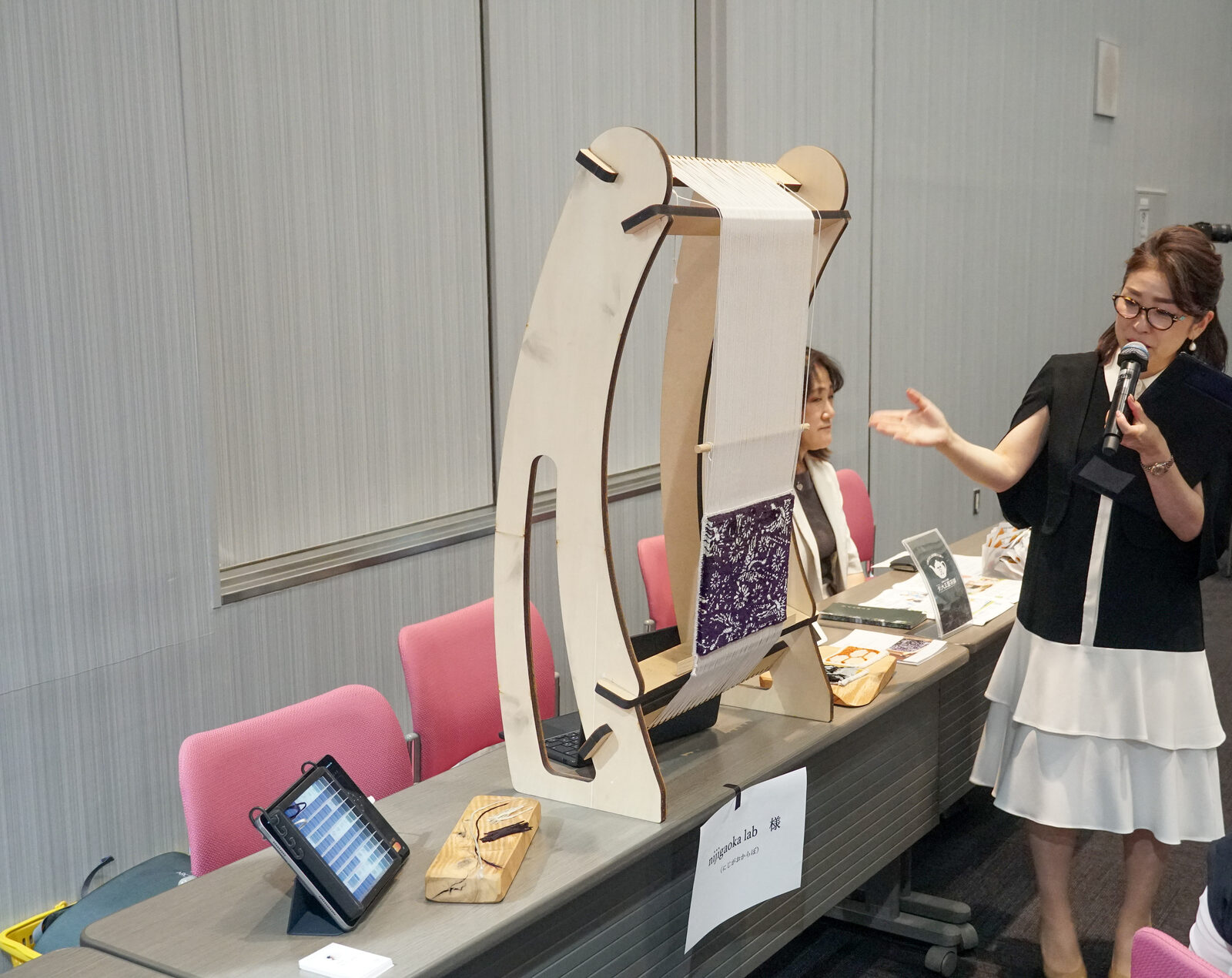 物販ブースのテーブルに木製のハープやアクセサリーが並び、スタッフが商品を紹介している。